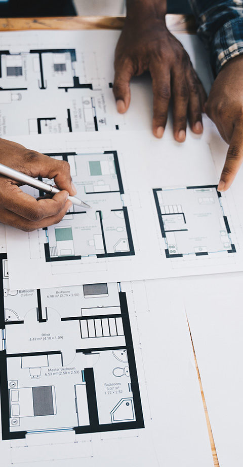 hands reviewing architectural plans and drawings for a residential layout including detailed measurements for ten rooms and areas